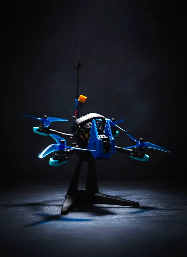 Дрон MARK5 в лучах драматичного студийного света. Крупный план на столе, подчеркивающий детали сборки и футуристичный дизайн